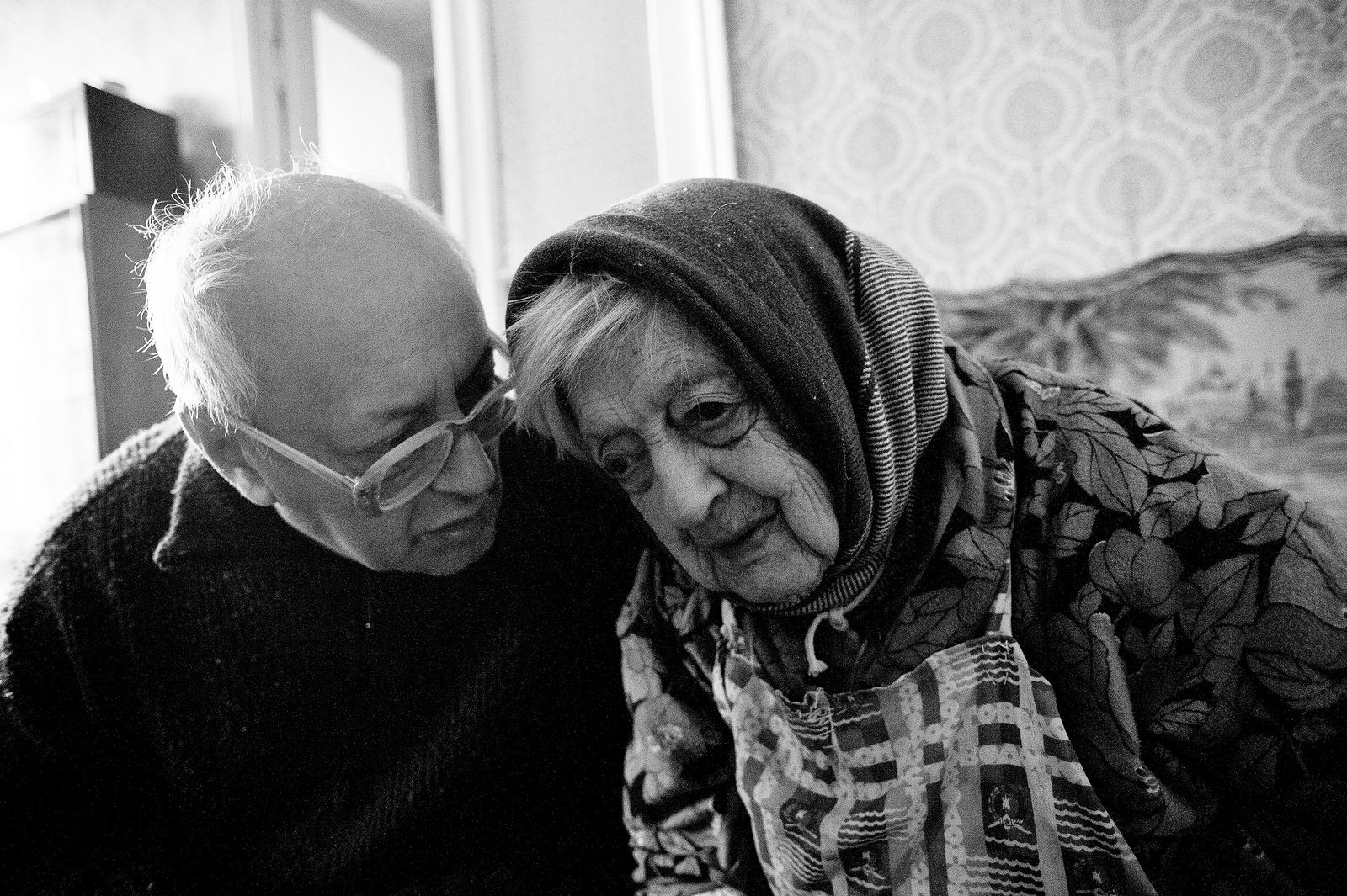 Arik Shraga. "Joint" Families: The Stories of Love. Victor and his mother Sheiva Sheiva lives with her son who suffers from a severe form of diabetes and can’t live on his own. He is nervous and constantly hesitates, being afraid to make something wrong. He never had an own family and has always been highly dependant on his mother, both materially and emotionally.
Sheiva can hardly see and can’t hear. But she can tell stories. She revealed for me a secrets of her gefilte-fish: “Never ever put beet into it!” whispers Sheiva as if it were a secret of happiness...