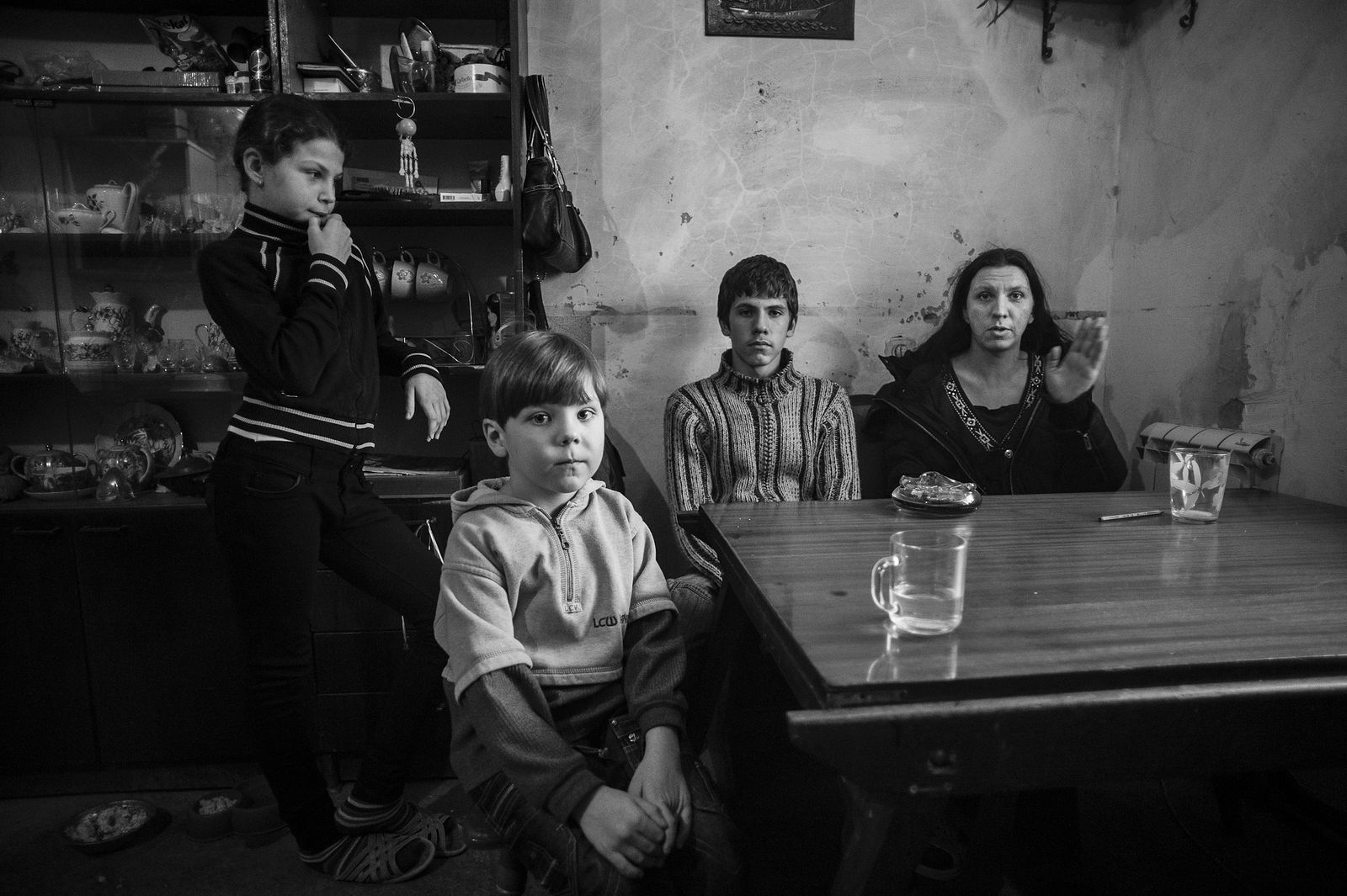 Арик Шрага. Украина. Ольга и ее дети У Ольги трое детей, которых она воспитывает одна, и почти нет доходов. Однако она организовала во дворе своего дома приют для собак и спасает от бездомного существования женщину с маленьким ребенком.